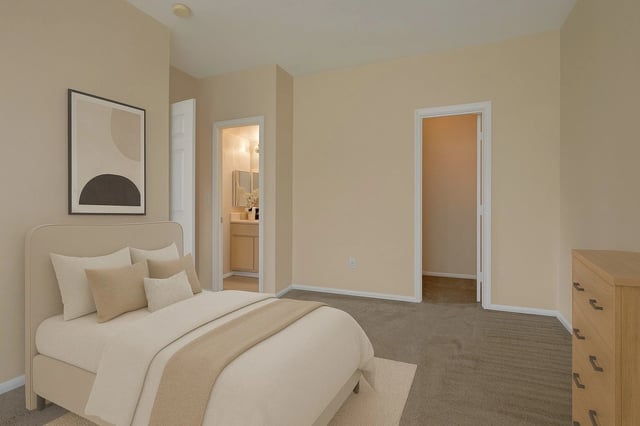 Bedroom with a queen-size bed, ensuite bathroom, and a dresser.