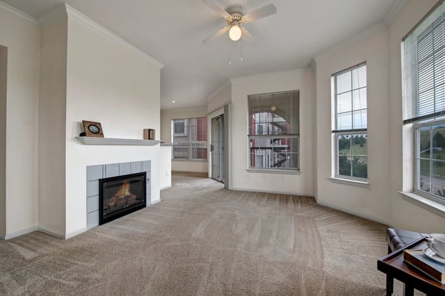 Living room with a fireplace and ceiling fan.
