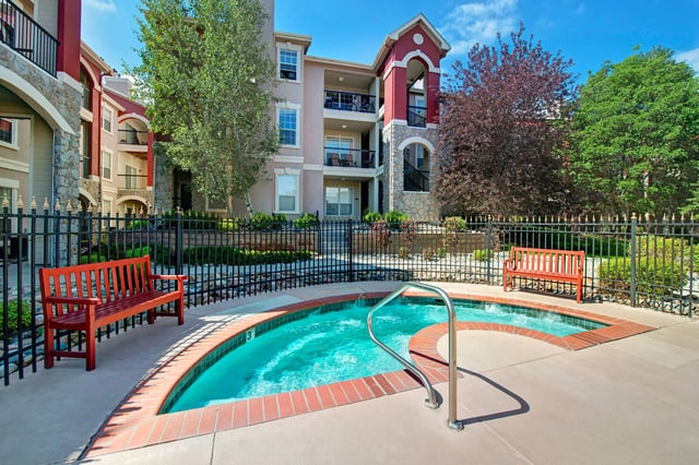 Outdoor spa with jets and surrounding benches.