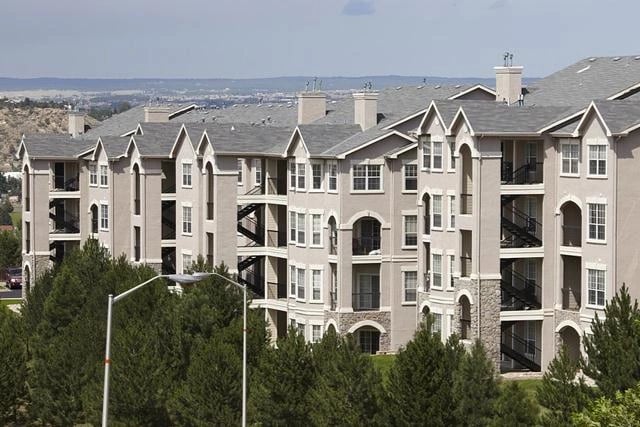 Exterior view of a large apartment building with multiple stories and balconies.
