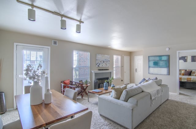 Living room and dining area with a fireplace and a view into the bedroom.
