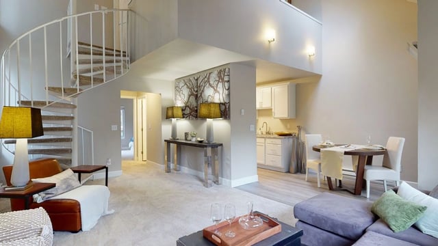 Living area with spiral staircase and dining area.
