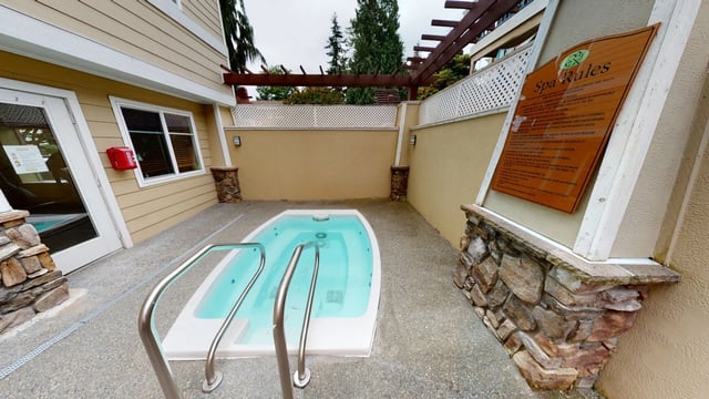 Outdoor hot tub with spa rules sign.