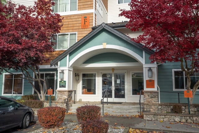 Exterior view of the Forest Hills apartment building entrance with fall foliage.