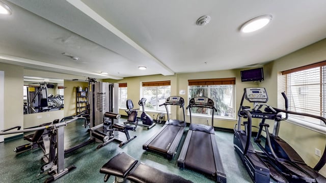 Fitness center with treadmills, ellipticals, and weight machines.