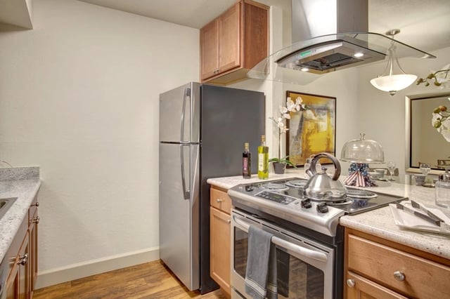 Modern kitchen with stainless steel appliances, including a refrigerator and stove.
