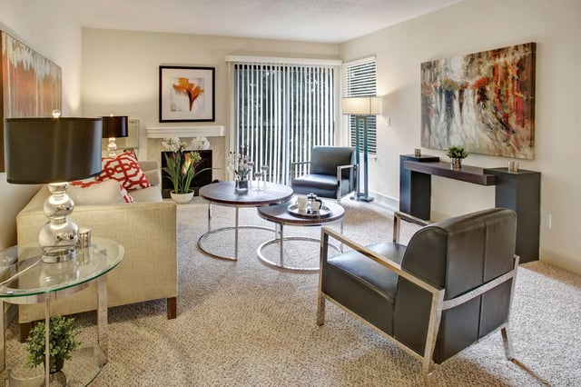 Modern living room with fireplace, coffee table, and artwork.