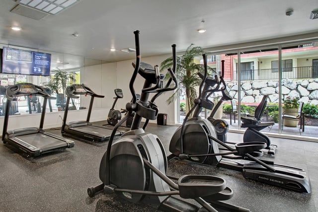 Treadmills and elliptical machines in the apartment complex gym.