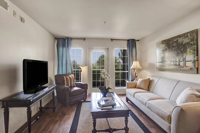 Living room with a sofa, armchair, coffee table, and TV.