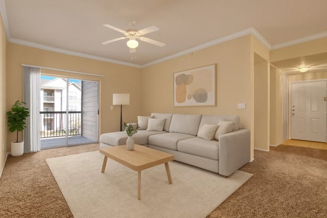 Living room with a sectional sofa, coffee table, and balcony access.