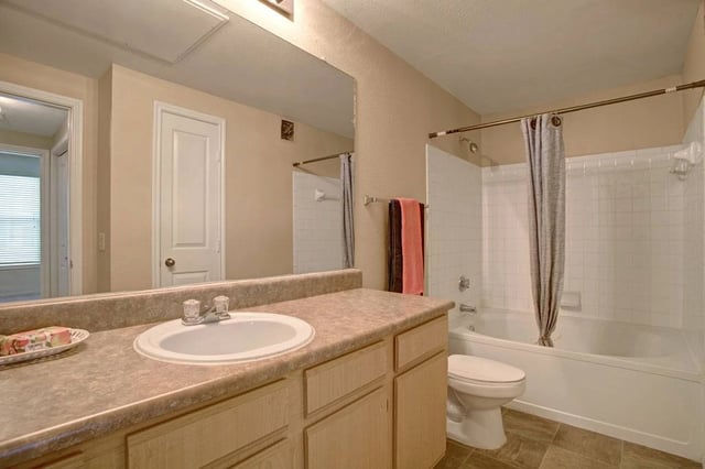 Bathroom with vanity, sink, toilet, and bathtub.