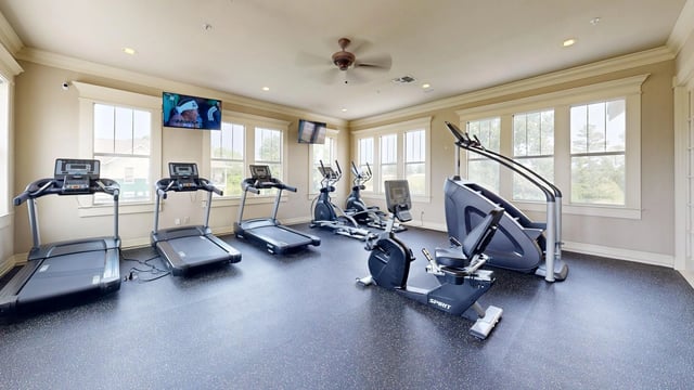 Gym with treadmills, ellipticals, stair climber, and recumbent bike.