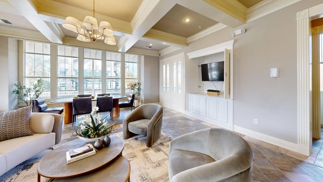 Lounge area with comfortable seating, dining table, and large windows.