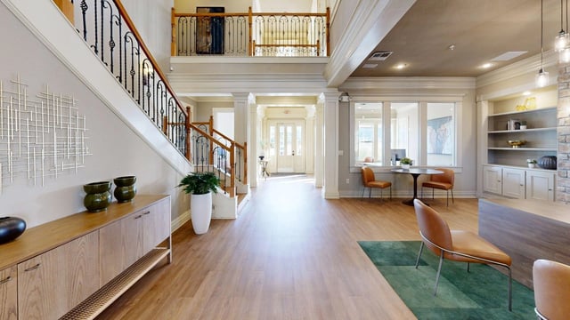 Interior lobby with staircase, seating area, and reception desk.