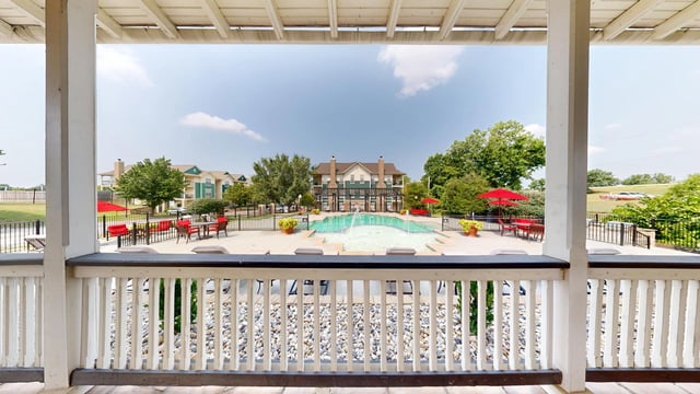 View of the resort-style pool and surrounding patio area with lounge chairs and tables.