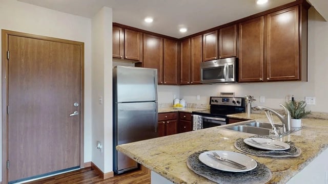 Modern kitchen with stainless steel appliances and granite countertops.