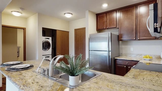 Kitchen with granite countertops, stainless steel appliances, and washer/dryer.