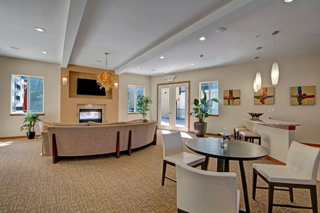 Clubhouse lounge area with fireplace, seating, and bar.