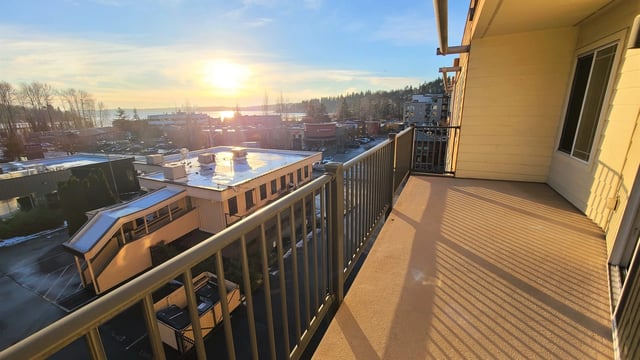 Balcony view with sunset over buildings and water