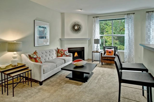 Living room with a sofa, fireplace, and large window.