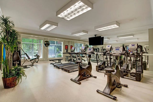 Fitness center with treadmills, elliptical machines, stationary bikes, and weight machines.