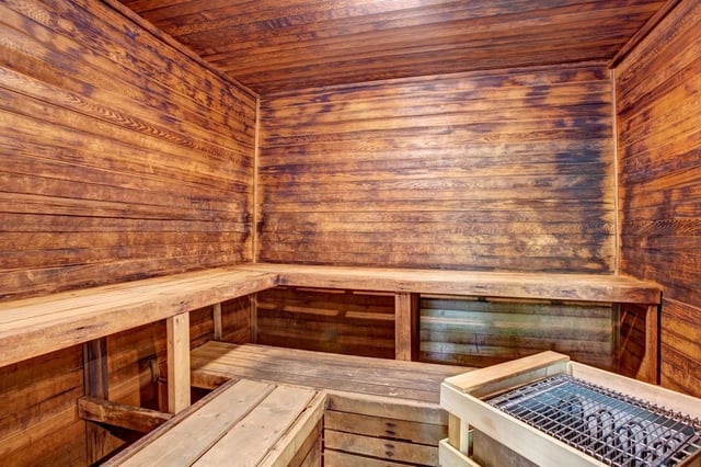 Interior of a wooden sauna with benches and a heater.