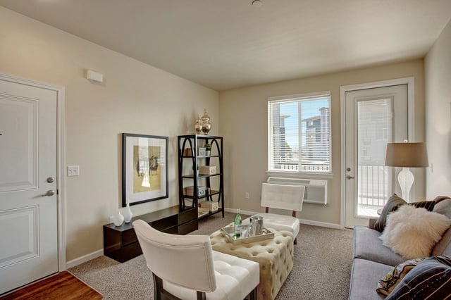 Living room with a sofa, ottoman, chairs, and decor.