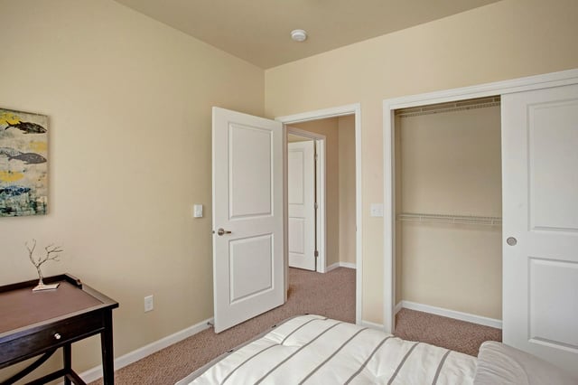 Interior view of a bedroom with a closet and a desk.