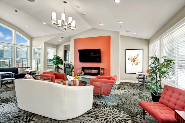 Lobby with modern seating, fireplace, and large windows.
