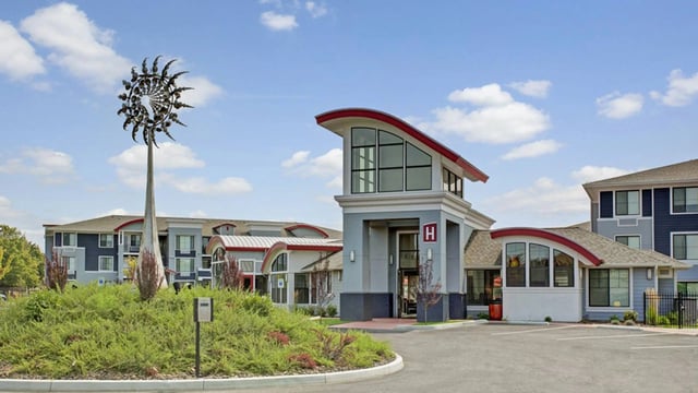 Apartment building exterior with a distinctive sculpture and entrance.