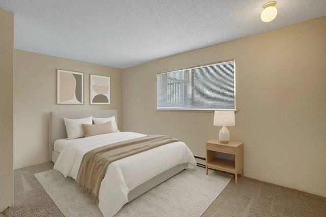 Bedroom with a queen-sized bed, nightstand, and window.