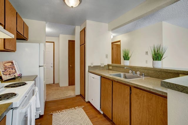 Kitchen with white appliances and wooden cabinets.