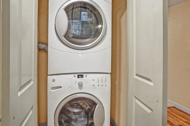 Stacked GE washer and dryer in a laundry closet.