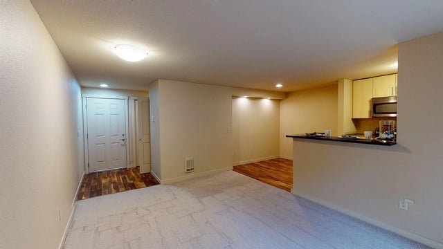 Living room with entryway and open kitchen view