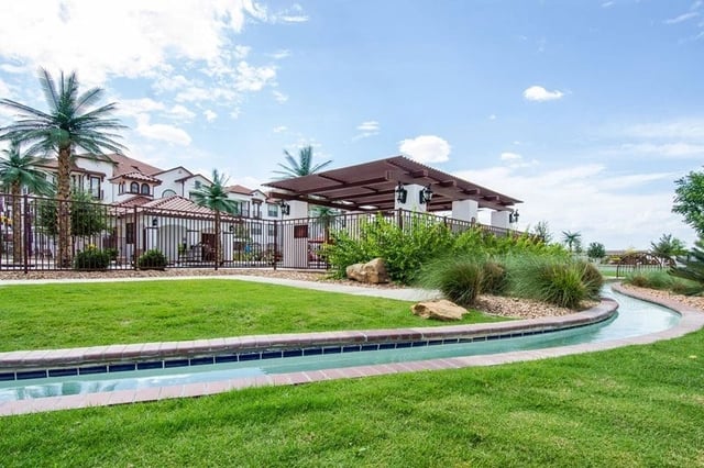 A lazy river water feature and poolside cabana at a luxury apartment complex.