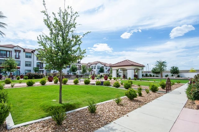 Apartment complex courtyard with a gazebo and manicured landscaping.