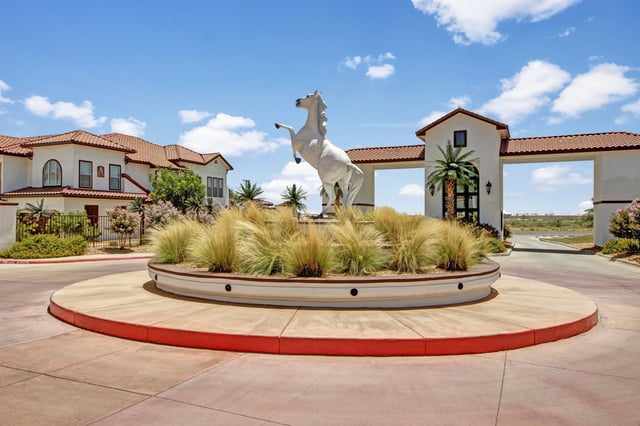 White horse statue and landscaped roundabout at the entrance to the apartment complex.