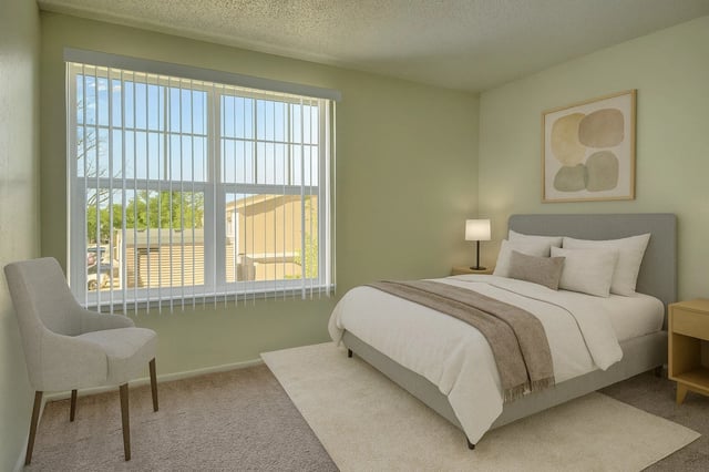 Bedroom with a queen-size bed, nightstand, and accent chair.