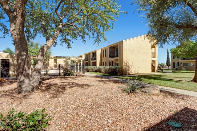 Exterior view of apartment buildings with a courtyard and trees.