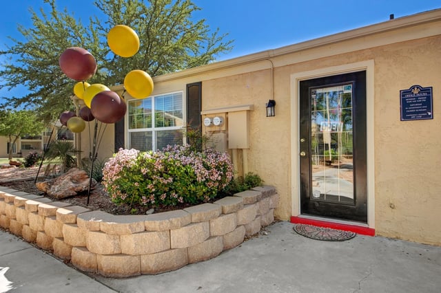 Office building entrance with balloons and landscaping.