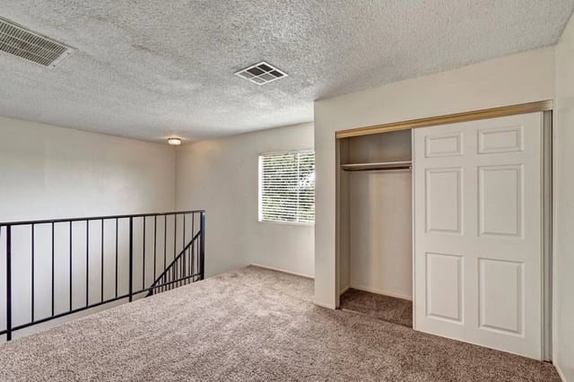 Interior of a bedroom with a closet and a window.