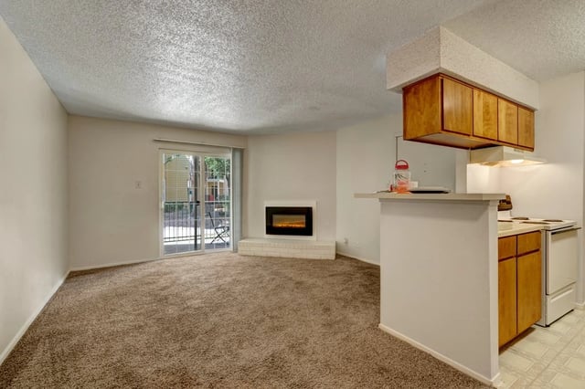 Living room with fireplace and adjoining kitchen