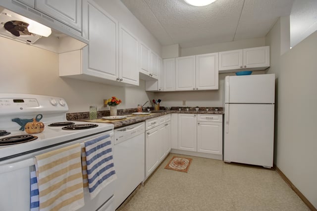 Kitchen with white cabinets, white appliances, and granite countertops.