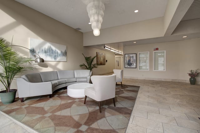 Modern lobby with curved sofa, round coffee table, and accent chairs.