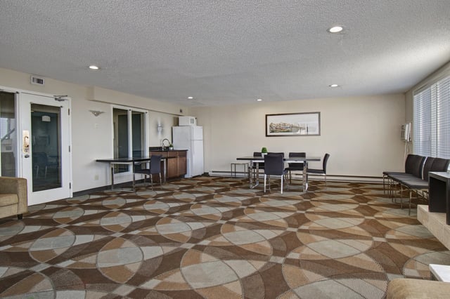 Community room with dining tables, chairs, a small kitchenette, and seating area.
