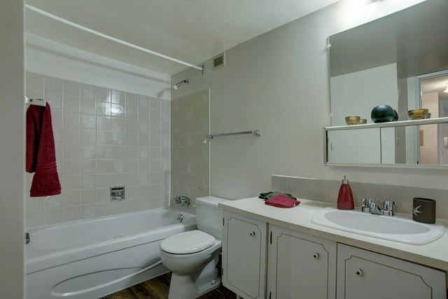 Bathroom with a bathtub, toilet, and vanity with a sink.