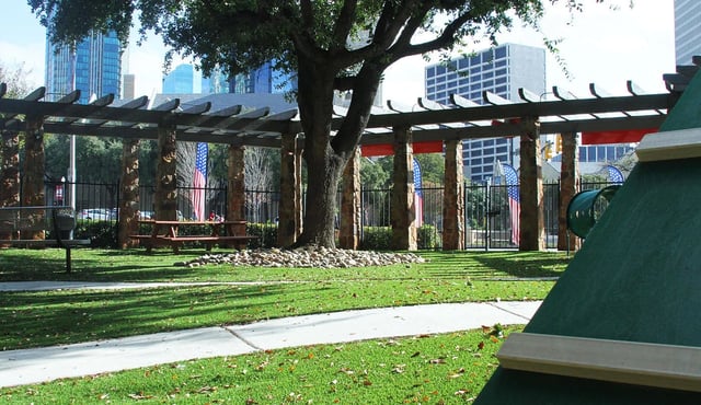Outdoor community courtyard with a pergola, trees, and benches.