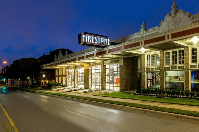 Exterior view of the Firestone apartment community at night with an illuminated sign.