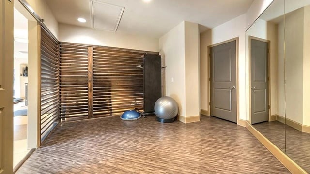 Interior of a gym with a weight bench, exercise ball, and bosu ball.