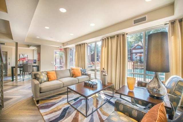 Lounge area with comfortable seating and view of the community pool.